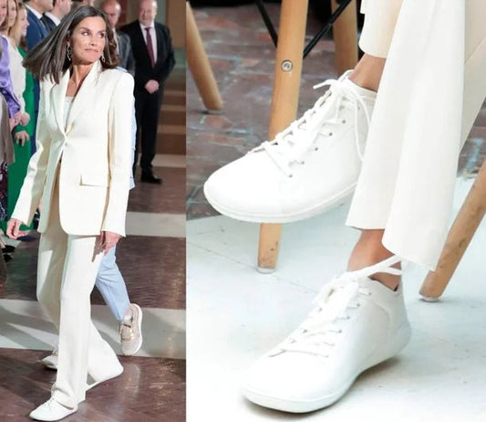 La Reina Letizia usando zapatillas barefoot en un evento público, destacando la combinación de estilo y comodidad que ofrece el calzado minimalista como el de BareMotion Barefoot